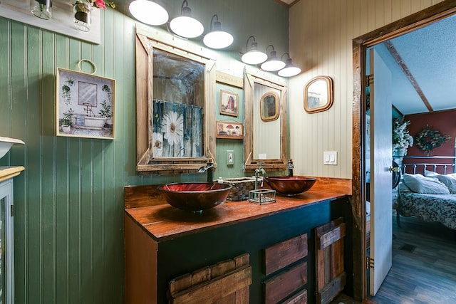 bathroom featuring vanity, hardwood / wood-style flooring, wooden walls, and a shower with shower curtain