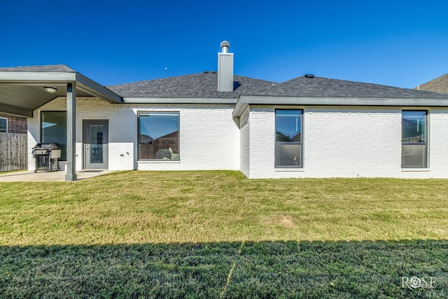 rear view of property featuring a patio area and a lawn