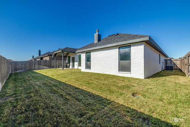 back of property featuring a yard and central air condition unit