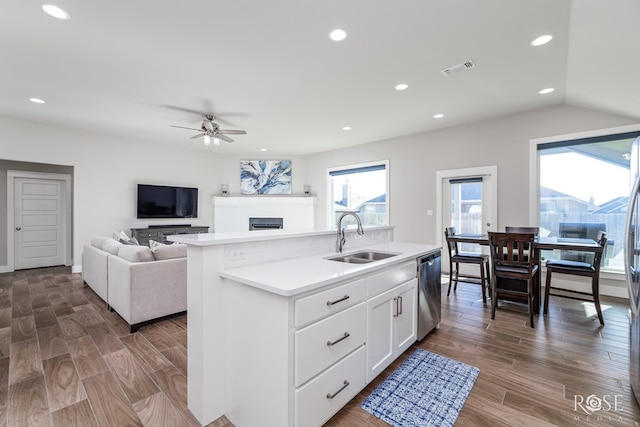 kitchen featuring sink, white cabinetry, a center island with sink, dishwasher, and ceiling fan