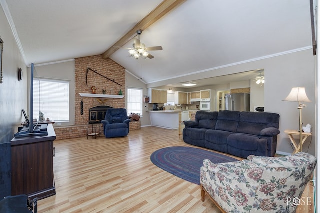 living room with crown molding, ceiling fan, a fireplace, lofted ceiling with beams, and light hardwood / wood-style floors