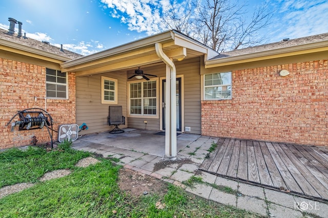 entrance to property with a patio, ceiling fan, and a deck