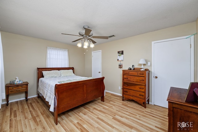 bedroom featuring light wood-type flooring, a textured ceiling, and ceiling fan