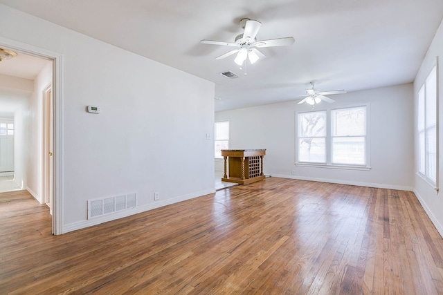 1221 Howard Ave, San Angelo, TX 76901 - unfurnished living room with healthy amount of natural light, a ceiling fan, and wood finished floors