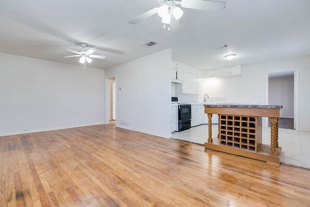 1221 Howard Ave, San Angelo, TX 76901 - unfurnished living room with a ceiling fan and light wood-style floors