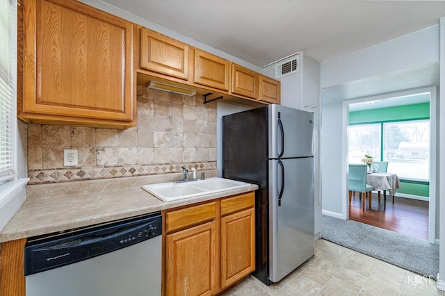 kitchen with tasteful backsplash, sink, and appliances with stainless steel finishes