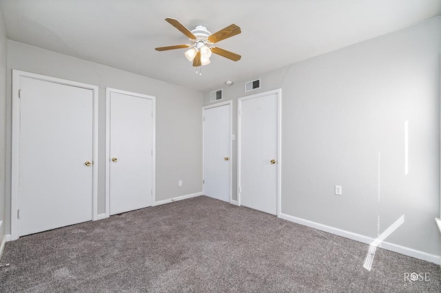 unfurnished bedroom with multiple closets, ceiling fan, and carpet floors