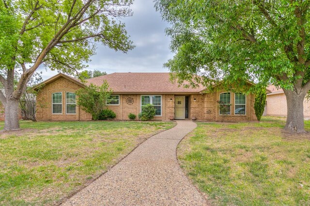 single story home featuring brick siding and a front yard