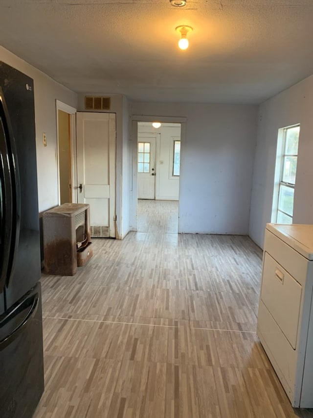 620 W 19th St, San Angelo, TX 76903 - kitchen featuring freestanding refrigerator, light wood-style floors, washer / clothes dryer, white cabinetry, and a textured ceiling