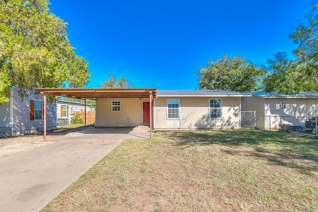 single story home featuring a carport, a front yard, and central AC unit