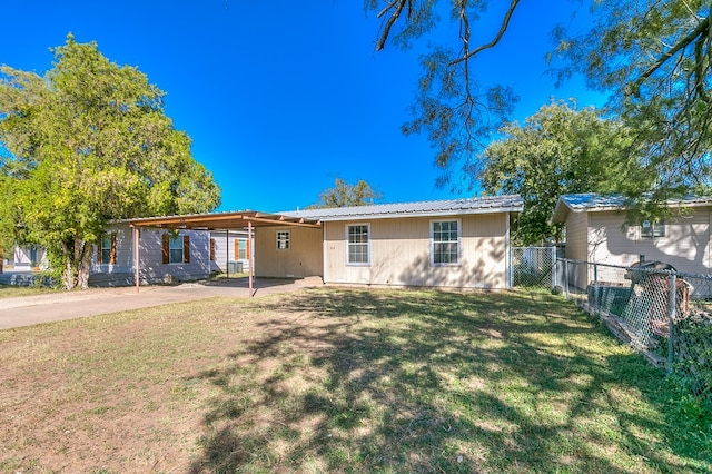 back of house featuring a lawn and a carport