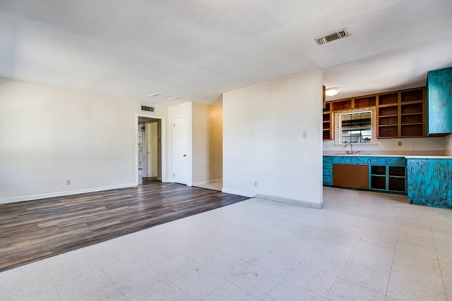 unfurnished living room with sink and a textured ceiling