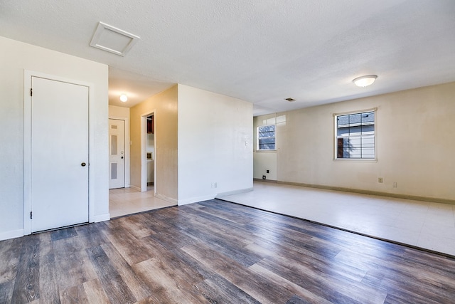 unfurnished room featuring hardwood / wood-style flooring and a textured ceiling