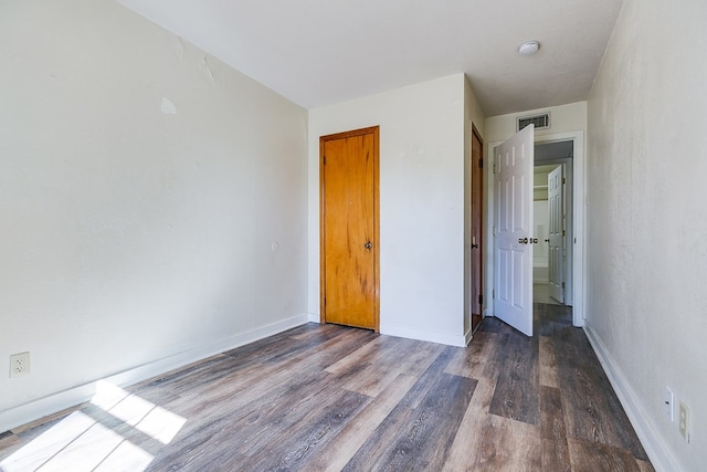 unfurnished bedroom with dark wood-type flooring