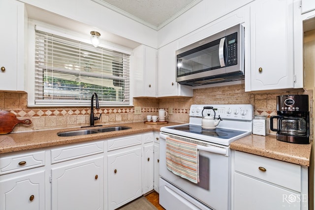 2713 Canyon Creek Dr, San Angelo, TX 76904 - kitchen featuring white range with electric stovetop, stainless steel microwave, a sink, crown molding, and white cabinets
