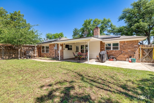 2713 Canyon Creek Dr, San Angelo, TX 76904 - rear view of house with solar panels, a chimney, and brick siding