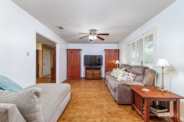 2713 Canyon Creek Dr, San Angelo, TX 76904 - living room featuring ceiling fan, light wood-style flooring, and a textured ceiling