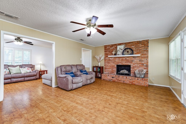 2713 Canyon Creek Dr, San Angelo, TX 76904 - living area featuring a ceiling fan, crown molding, wood finished floors, a textured ceiling, and a fireplace
