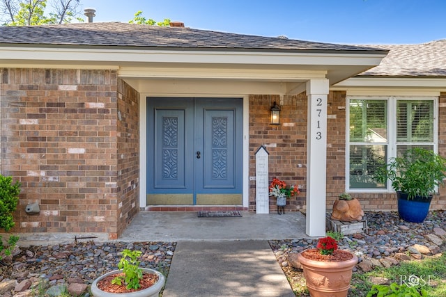 2713 Canyon Creek Dr, San Angelo, TX 76904 - view of exterior entry featuring brick siding and a shingled roof