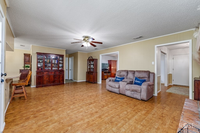 2713 Canyon Creek Dr, San Angelo, TX 76904 - living room with light wood finished floors, a ceiling fan, a textured ceiling, ornamental molding, and baseboards