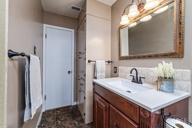 2713 Canyon Creek Dr, San Angelo, TX 76904 - bathroom with vanity, decorative backsplash, stone finish floors, and a textured ceiling