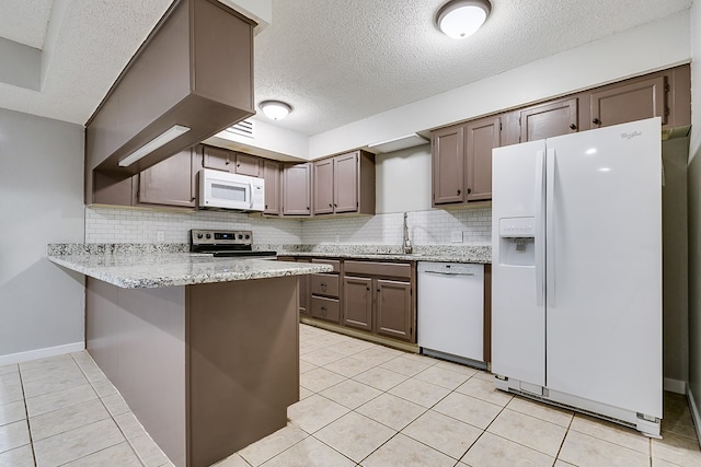 kitchen with sink, tasteful backsplash, light tile patterned floors, kitchen peninsula, and white appliances