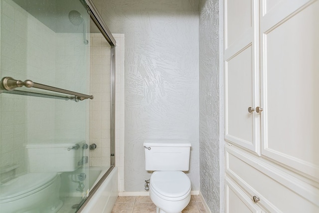 bathroom featuring shower / bath combination with glass door, tile patterned floors, and toilet