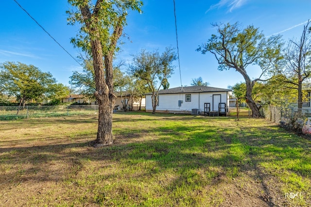 view of yard with a fenced backyard and central AC