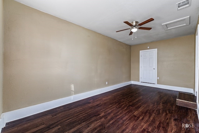 unfurnished room featuring attic access, visible vents, baseboards, dark wood-style floors, and ceiling fan