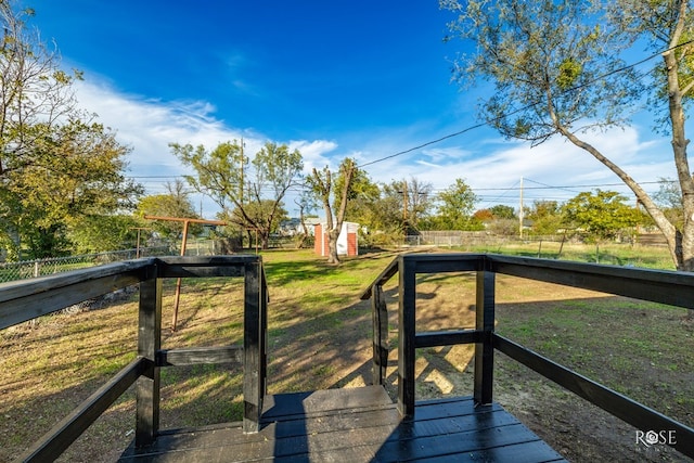 wooden terrace with a lawn and fence