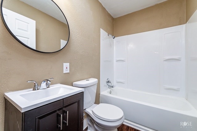 bathroom featuring a textured wall, vanity, toilet, and shower / bathtub combination