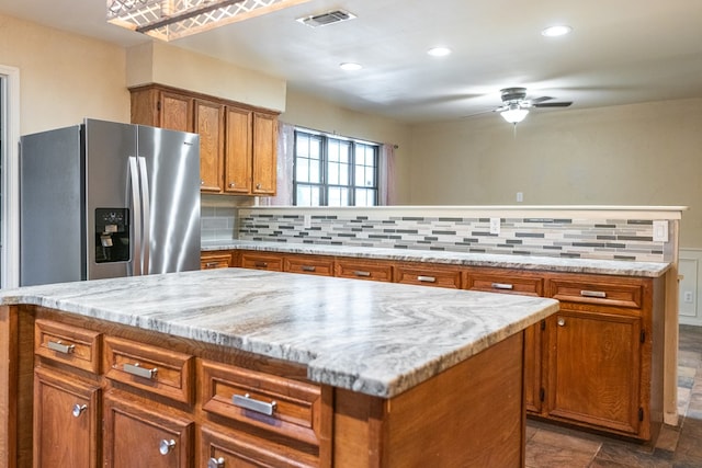 3329 Clearview Dr, San Angelo, TX 76904 - kitchen featuring stainless steel fridge, brown cabinets, ceiling fan, tasteful backsplash, and recessed lighting
