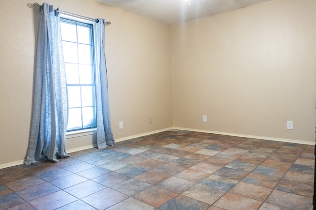 3329 Clearview Dr, San Angelo, TX 76904 - spare room featuring baseboards, a textured ceiling, and stone finish floors