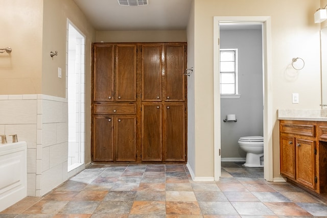 3329 Clearview Dr, San Angelo, TX 76904 - full bath featuring toilet, vanity, stone finish floors, baseboards, and a closet
