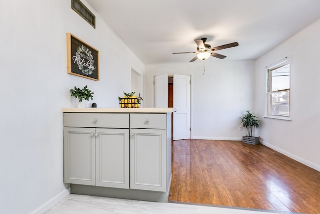 kitchen featuring gray cabinets, ceiling fan, and light hardwood / wood-style floors