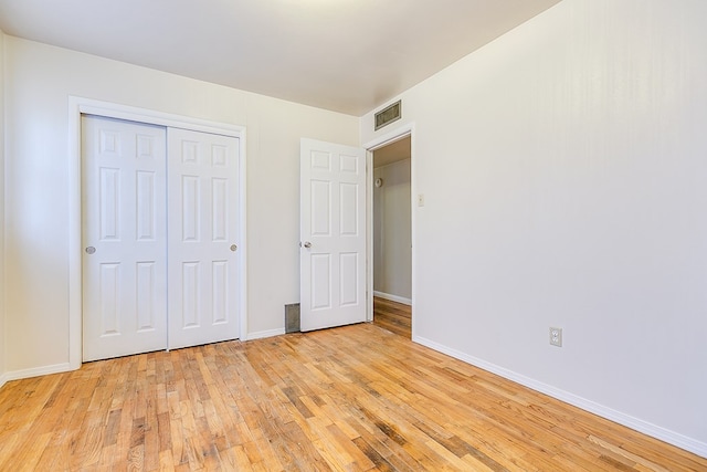 unfurnished bedroom featuring a closet and light wood-type flooring