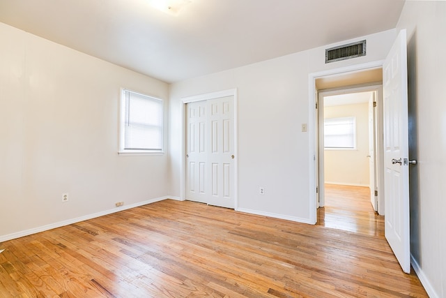 unfurnished bedroom with a closet and light wood-type flooring