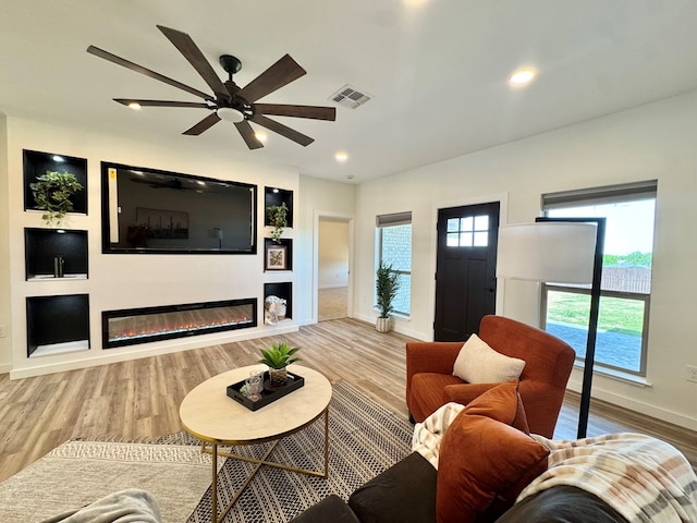 3634 Silver Spur Dr, San Angelo, TX 76904 - living area with baseboards, wood finished floors, a glass covered fireplace, ceiling fan, and recessed lighting