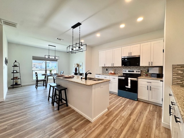 3634 Silver Spur Dr, San Angelo, TX 76904 - kitchen with stainless steel electric range, a sink, light wood-style flooring, decorative backsplash, and white cabinetry