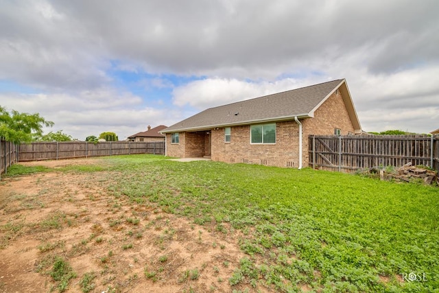 4506 Oak Grove Blvd, San Angelo, TX 76904 - back of house with a lawn, brick siding, a shingled roof, and a fenced backyard