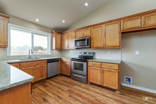 4506 Oak Grove Blvd, San Angelo, TX 76904 - kitchen with appliances with stainless steel finishes, a sink, tasteful backsplash, vaulted ceiling, and dark wood-style floors