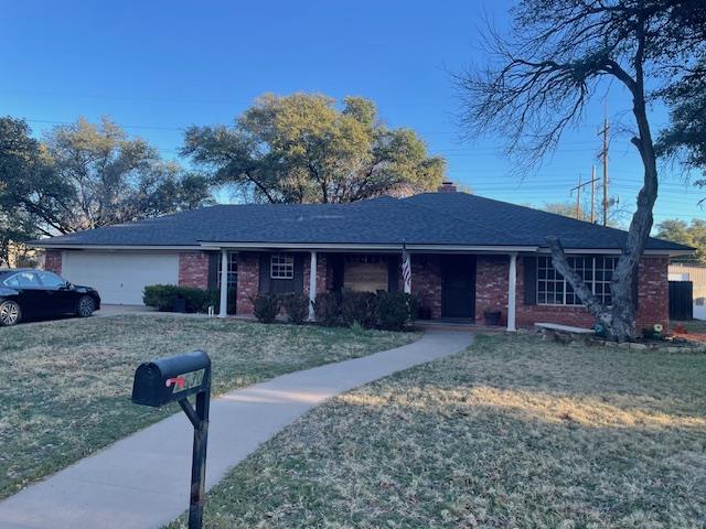 ranch-style home with a garage and a front yard