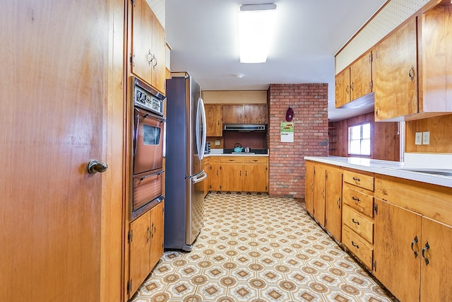 2645 A & M Ave, San Angelo, TX 76904 - kitchen with freestanding refrigerator, wall oven, light countertops, brown cabinetry, and a warming drawer