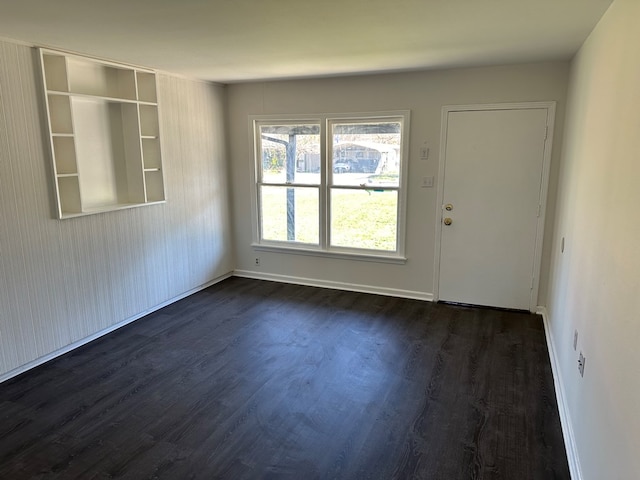 empty room with baseboards and dark wood finished floors