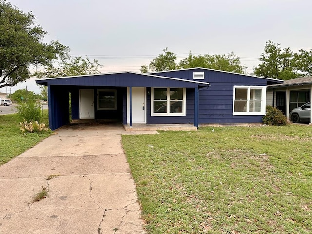 view of front of house featuring a carport, a front yard, and driveway
