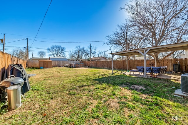view of yard with a storage shed, a patio, and a fenced backyard