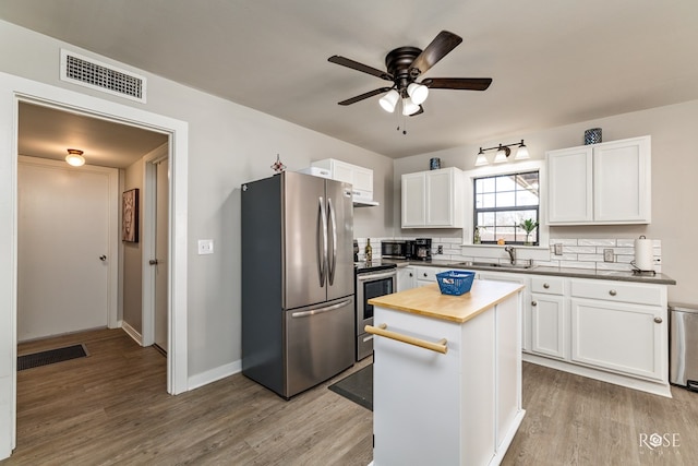 kitchen with visible vents, stainless steel appliances, light wood-style flooring, and white cabinetry