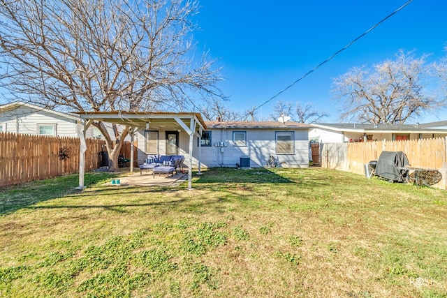 back of property with outdoor lounge area, a patio, a fenced backyard, and a lawn