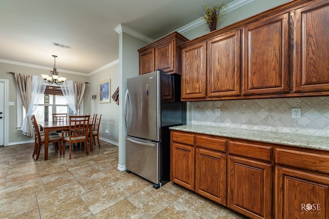 4641 Southland Blvd, San Angelo, TX 76904 - kitchen featuring freestanding refrigerator, baseboards, crown molding, decorative backsplash, and a chandelier