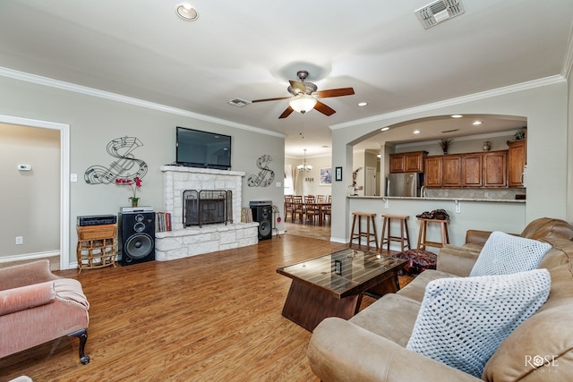 4641 Southland Blvd, San Angelo, TX 76904 - living room featuring crown molding, ceiling fan, a stone fireplace, arched walkways, and recessed lighting